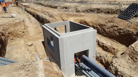 Chambre béton préfabriquée BEMACO posée en fouille, raccordement des fourreaux par un compagnon