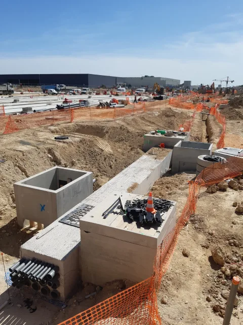 Plusieurs chambres béton préfabriquées BEMACO posées sur un chantier, avec fourreaux en attente